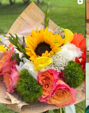 Warm-hued flower arrangement featuring orange blossoms and bright greens