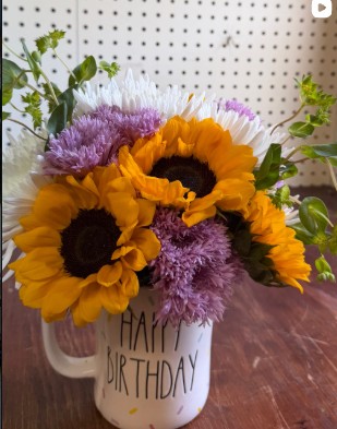 Sunflowers arranged with purple and pink garden flowers